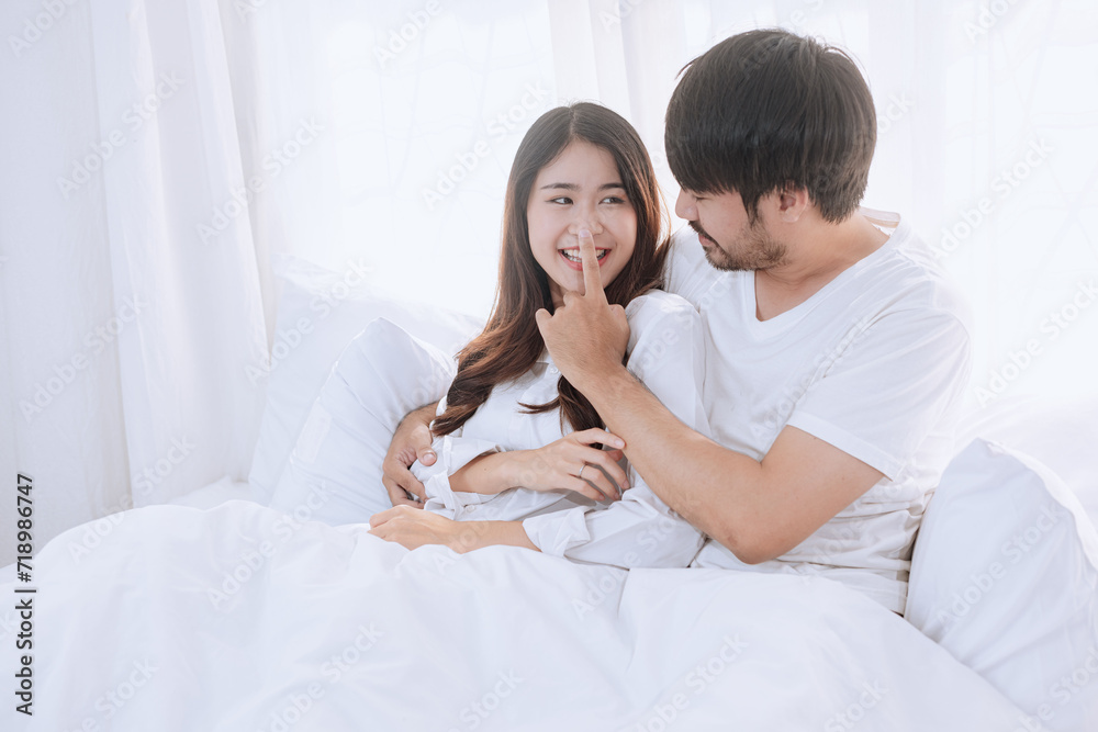 Happy love Asian young man and woman staying together in bedroom, Valentine's Day, Concept of holiday and surprise. Happy love Asian young man and woman staying together in bedroom, Valentine's Day, Concept of holiday and surprise.