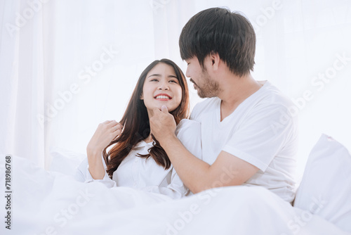 Happy love Asian young man and woman staying together in bedroom, Valentine's Day, Concept of holiday and surprise.