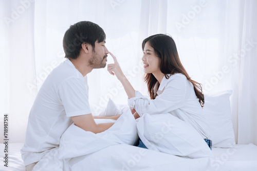Happy love Asian young man and woman staying together in bedroom, Valentine's Day, Concept of holiday and surprise.