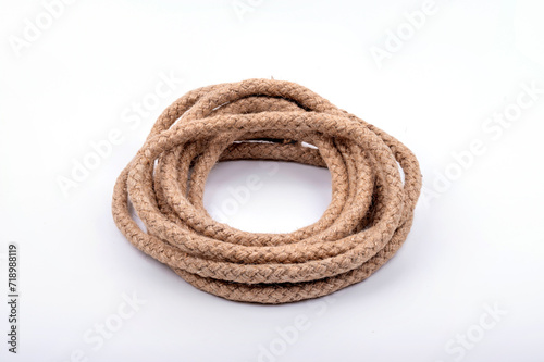 Jute rope rolled into a bay on a white background.