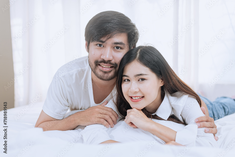Happy love Asian young man and woman staying together in bedroom, Valentine's Day, Concept of holiday and surprise. Happy love Asian young man and woman staying together in bedroom, Valentine's Day, Concept of holiday and surprise.