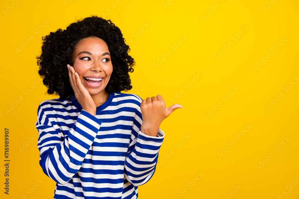 Portrait of impressed overjoyed girl look indicating at awesome sale empty space palm on cheek isolated on yellow color background Portrait of impressed overjoyed girl look indicating at awesome sale empty space palm on cheek isolated on yellow color background