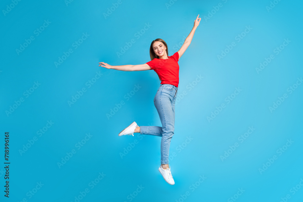 Full length photo of optimistic cheerful glad girl wear trendy red clothes flying air isolated on blue color background