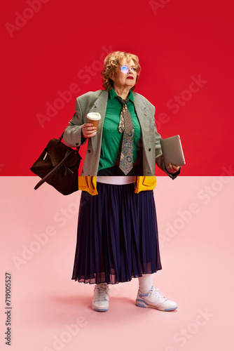 Fashion Fusion. Creative collage made of two halves of photos of mature woman in sport wear and smart casual outfit against pink -red background. Concept of active seniors in modern life. Ad