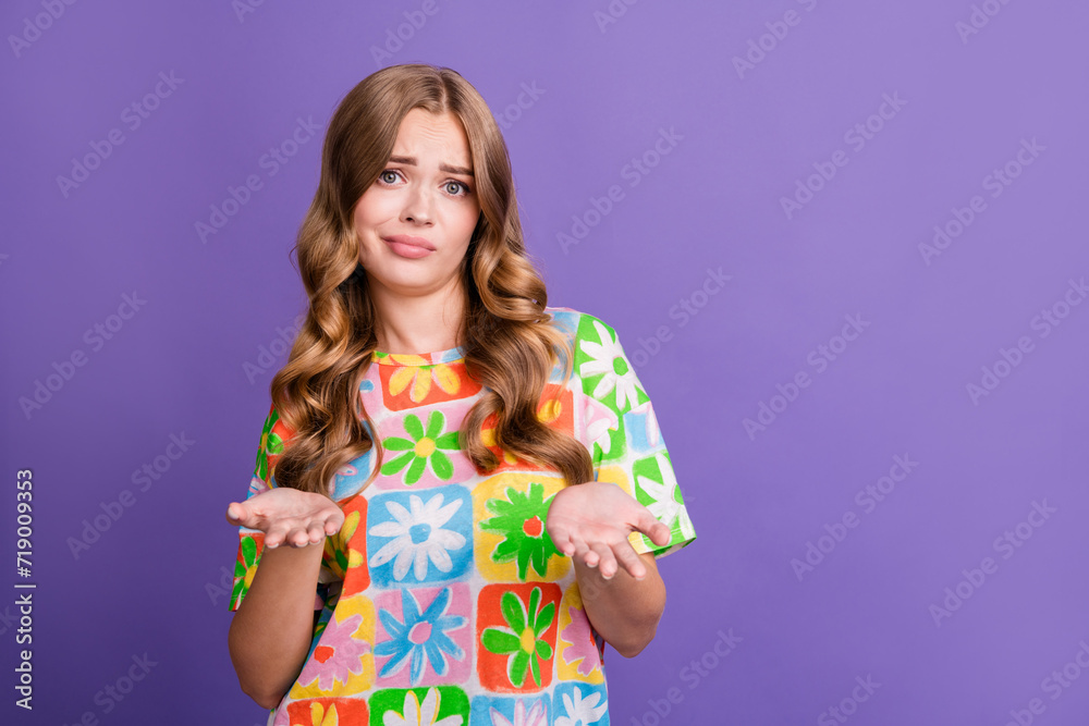 Portrait of clueless guilty confused girl with curly hairdo dressed print t-shirt shrugging shoulders isolated on violet color background Portrait of clueless guilty confused girl with curly hairdo dressed print t-shirt shrugging shoulders isolated on violet color background