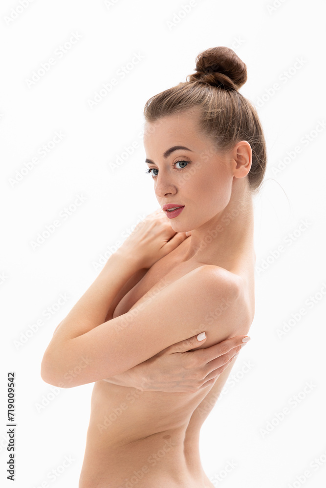 Beautiful topless young woman hugging herself by the shoulders and posing for the camera Beautiful topless young woman hugging herself by the shoulders and posing for the camera