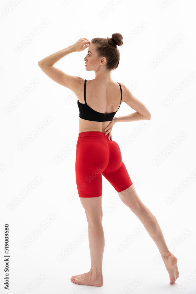 Slim sporty fitness young woman in black top and red leggings Slim sporty fitness young woman in black top and red leggings