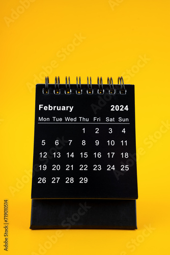 Black Calendar for February 2024. Desktop calendar on a yellow background.