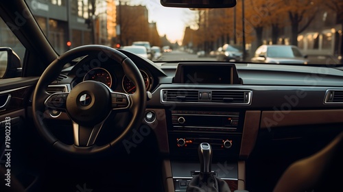 A photo captured from the middle of the back seat of a modern passenger car, showcasing the interior features such as steering wheel, gear shift, front windshield and dashboard