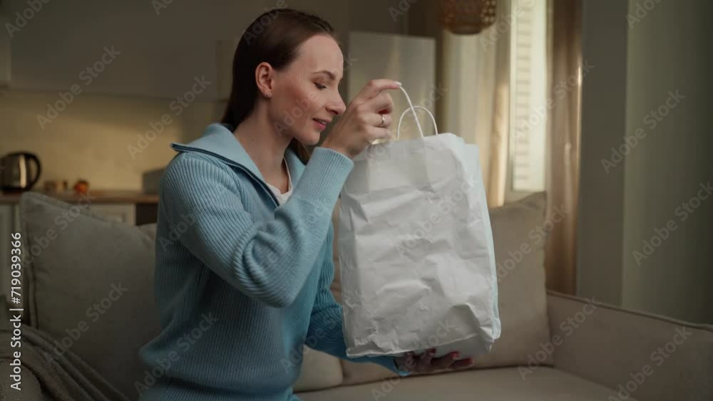 Female customer accepts a paper eco-bag with takeaway products from a male courier holding a paper bag delivering a takeaway order from a supermarket or restaurant. Female customer accepts a paper eco-bag with takeaway products from a male courier holding a paper bag delivering a takeaway order from a supermarket or restaurant.