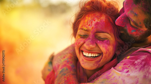 Human figures hugging and laughing, covered in a myriad of Holi colors