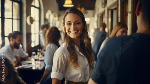 Happy waitress chatting with group of guests in bar photo