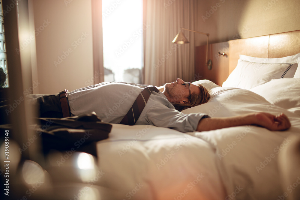 Businessman taking a nap in hotel room after work