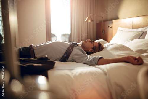 Businessman taking a nap in hotel room after work photo