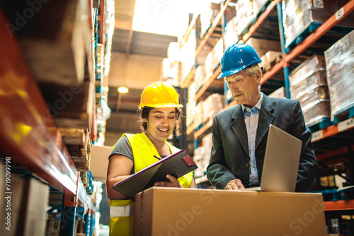 Female warehouse worker and senior male manager reviewing inventory photo