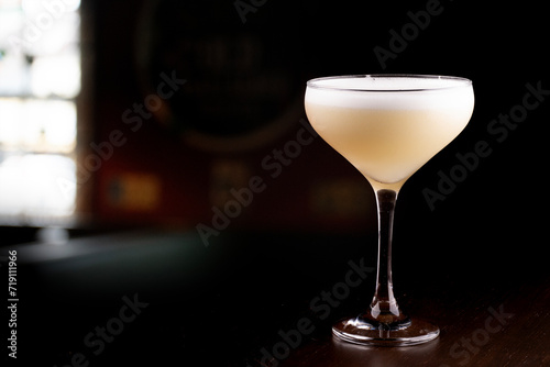 Cuadro en lienzo glass of pisco sour cocktail with blurred pub background in the corner