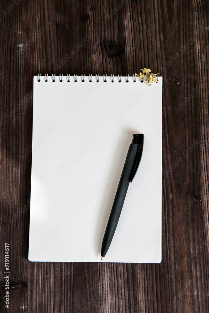 an open white notebook on a dark wooden background