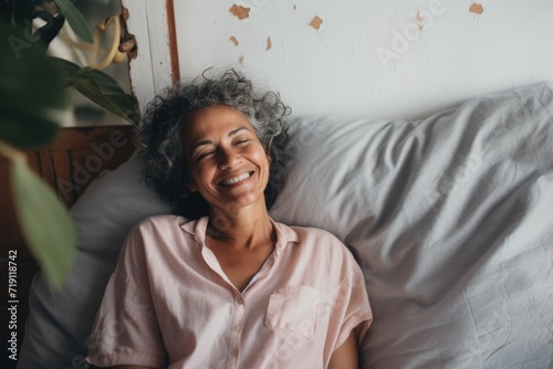 Portrait of a smiling senior hispanic woman in bed