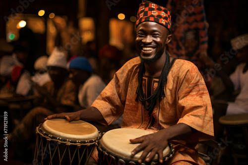An African male drummer, adorned in colorful attire, skillfully plays the drum photo