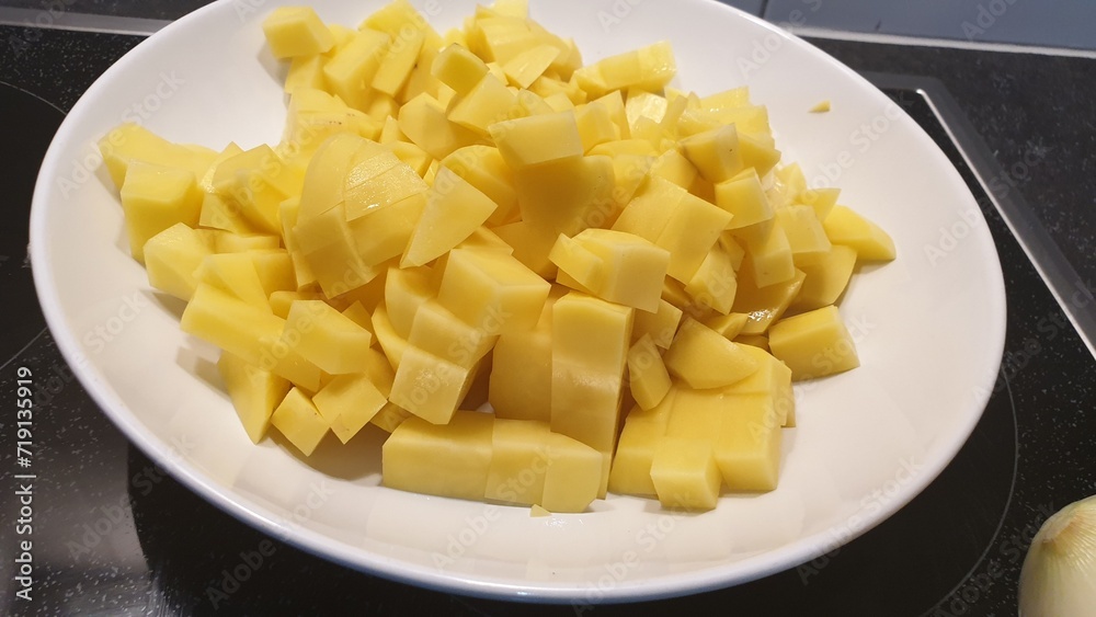Potatoes have been peeled and cut then put its into a white plate. Potatoes have been peeled and cut then put its into a white plate.
