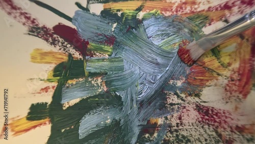 Mixing oil paints on a light background with a brush