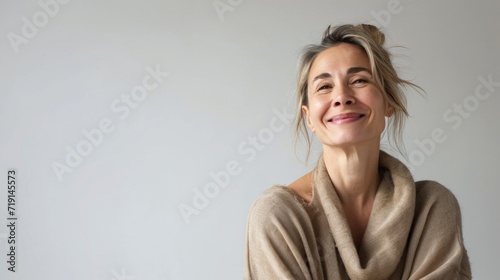 Portrait of a happy smiling mature woman looking beautiful standing isolated on white background in a sweater. Young female lady with a neutral smile.