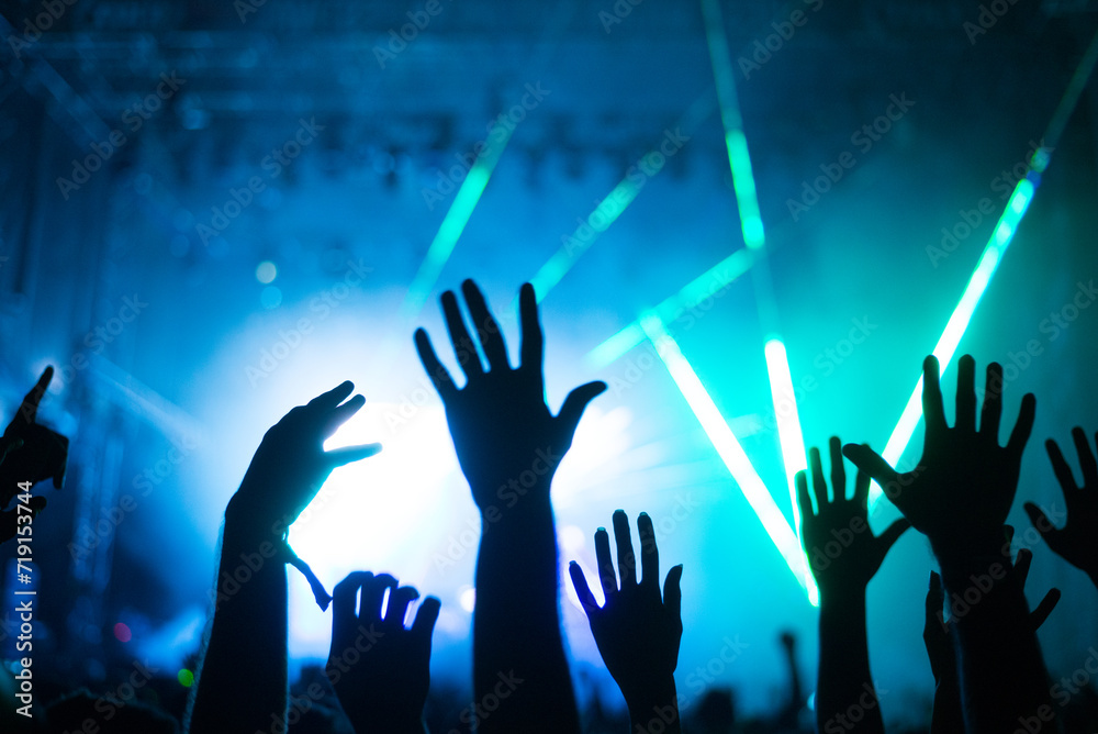 Crowd cheering and watching a band on stage, blurred motion, shallow DOF.