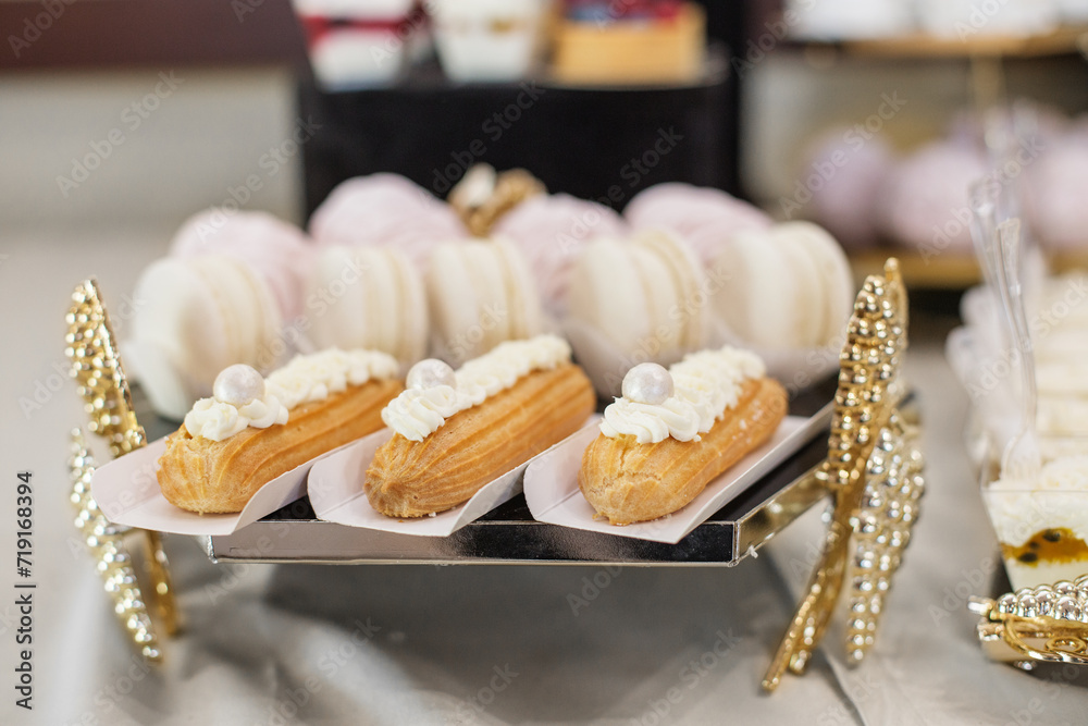 Candy bar. Food at event. Eclairs and Meringues on Elegant Dessert Tray