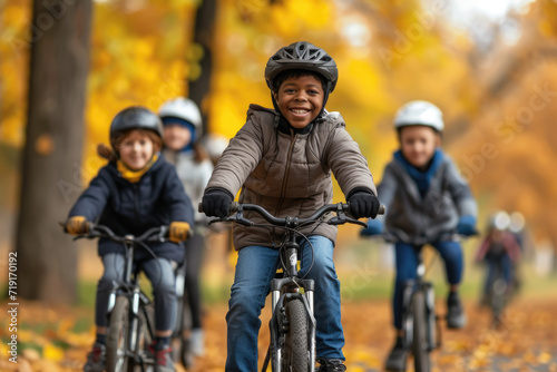 a diverse group of kids enjoying a group bike ride in the autumn park © Kien
