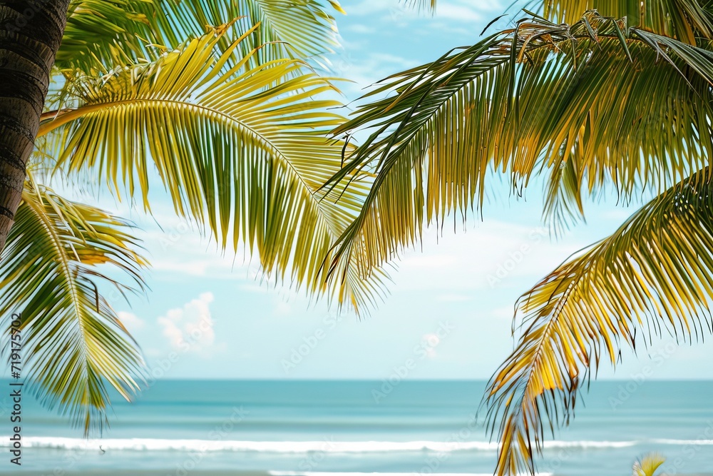 Tropical beach view framed by palm leaves with blue sky and fluffy clouds, conveying a serene vacation atmosphere.