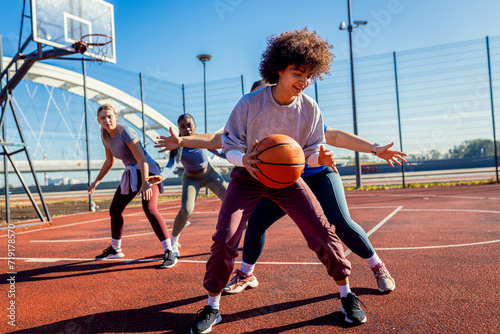 Diverse group of young woman having fun playing recreational basketball outdoors. © Zoran Zeremski