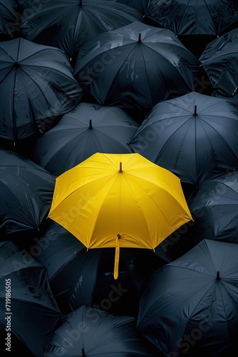 a yellow half transparent umbrella in the middle of a flock of black half transparent umbrellas