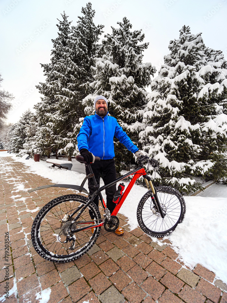 Happy bearded man with a bicycle in a winter city park Happy bearded man with a bicycle in a winter city park