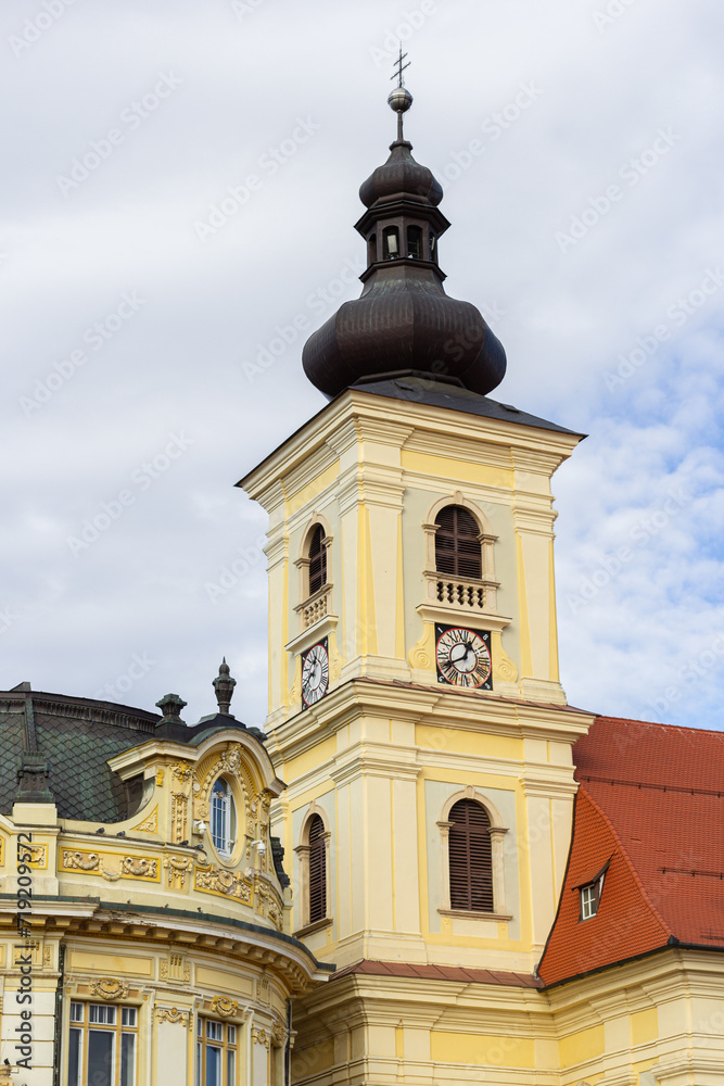The Holy Trinity Roman Catholic Church in Sibiu, Romania against the cloudy sky. A church bell tower in the old city center, in Transylvania