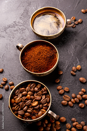 Coffee vertical background - cup of black coffee, coffee beans and ground coffee on a black background