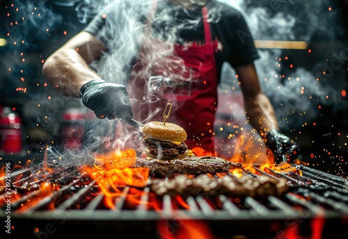 Professional chef masterfully prepares gourmet burgers on the grill among flames in a commercial kitchen © Яна Деменишина