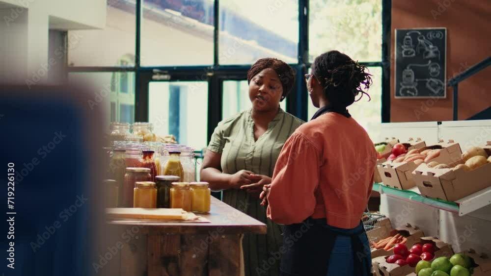 Merchant presenting homemade sauces and spices to client, promoting local farming and healthy eating. Storekeeper recommending bio organic bulk products at supermarket. Handheld shot. Merchant presenting homemade sauces and spices to client, promoting local farming and healthy eating. Storekeeper recommending bio organic bulk products at supermarket. Handheld shot.