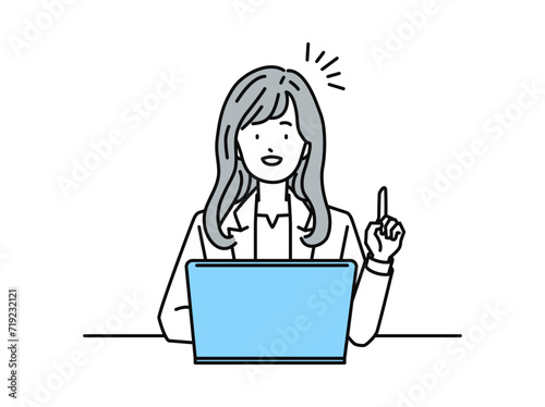 PCを操作しながら指差しポーズをする女性ビジネスパーソン(会社員)