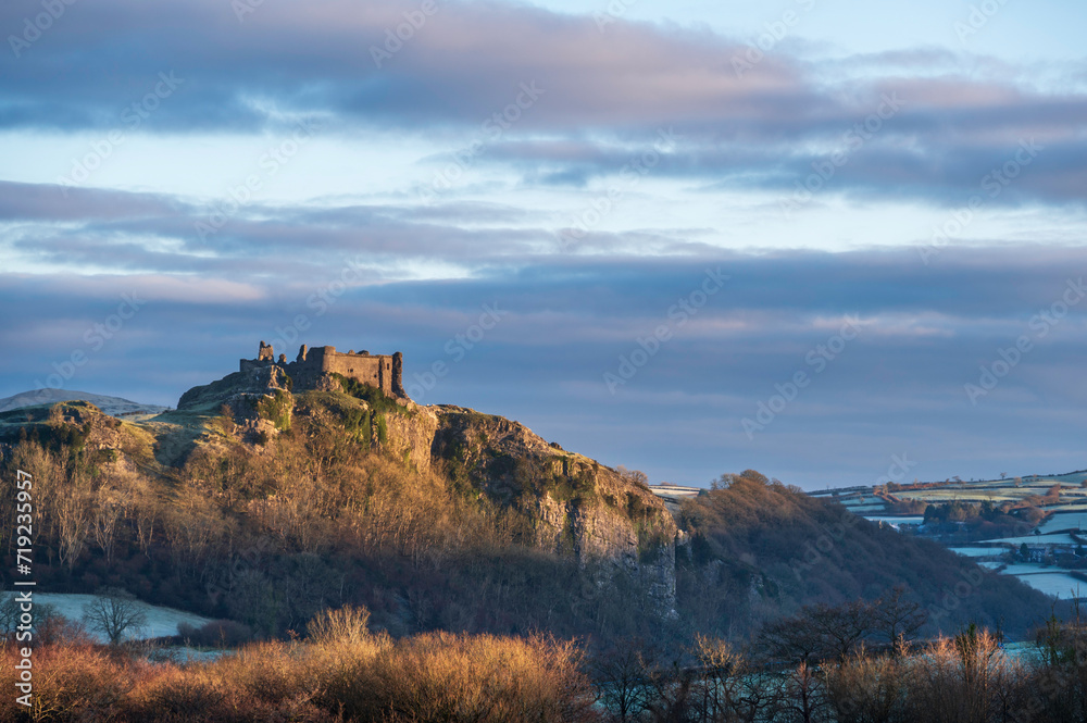 Obraz premium Carreg Cennan Castle, near Llandeilo, south Wales on a frosty winter's morning. The castle is located on a hilltop, overlooking the rural landscape