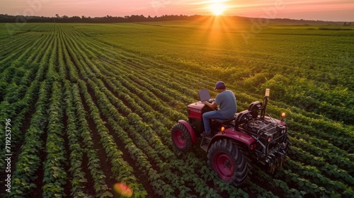 Farmer drives a tractor in a vast agricultural field, weeding, fertilizing and processing crops. Specialist uses modern technical means in his work. Smart farming, innovative agriculture.