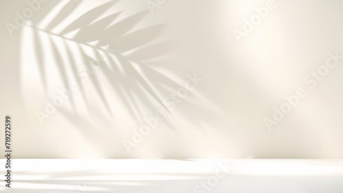 Blurred shadow from palm leaves on light cream wall. Minimalistic beautiful summer spring background for product presentation. © Laura Pashkevich