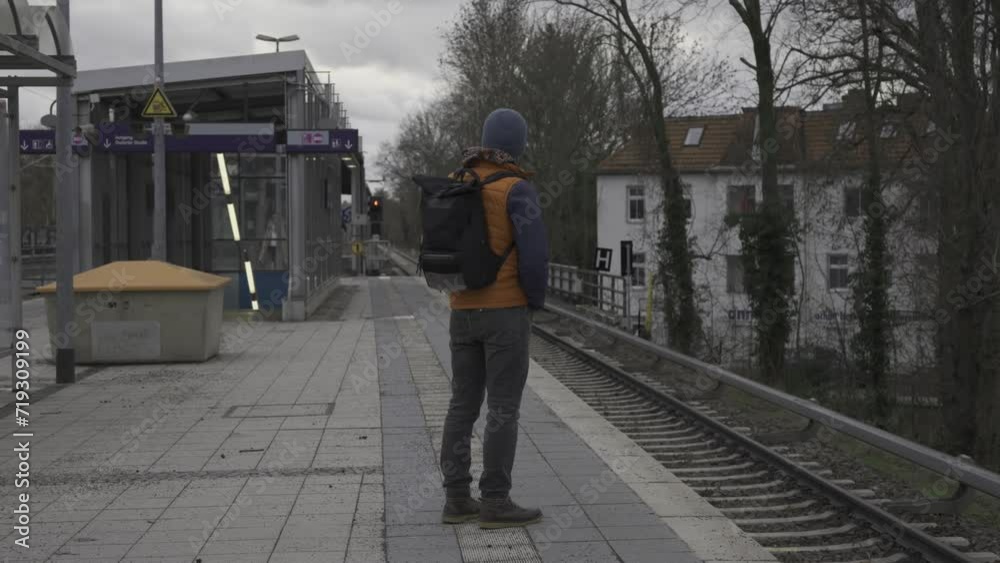 Train cancelations in Germany. Man waiting for long delayed commuter train at suburban railroad station in Berlin, Germany. Zug fallt aus, Deutschland. Railroad delays in Germany. Urban life citizen. Train cancelations in Germany. Man waiting for long delayed commuter train at suburban railroad station in Berlin, Germany. Zug fallt aus, Deutschland. Railroad delays in Germany. Urban life citizen.