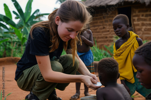 Female volunteer helps children in African village. Charitable support for children in need photo