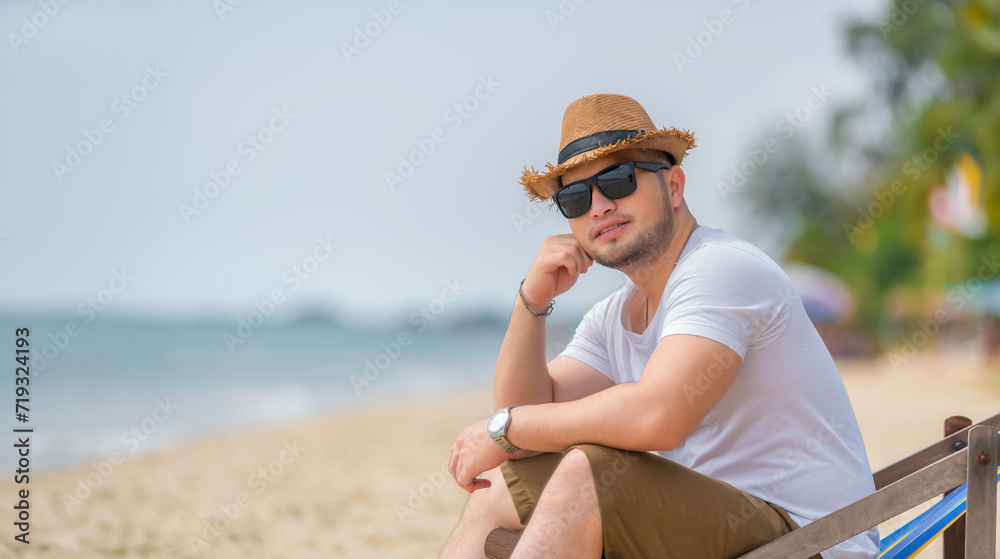 Asian man sitting chair beach inside sea,Relax time at summer