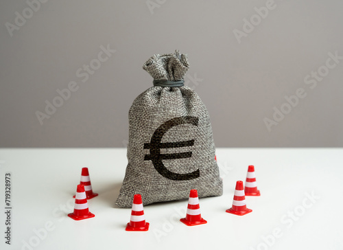 Euro money bag blocked by road cones. Suspicious funds with unknown sources. National money reserve. Freezing of accounts and sanctions on capital.