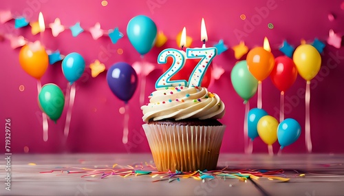 Birthday cupcake with burning lit candle with number 27. Number twentyseven for twentyseven years or twentyseventh anniversary. photo