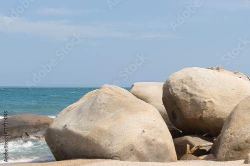 Big shore rocks with caribbean sea at background and blue sky at colombian tayrona park 