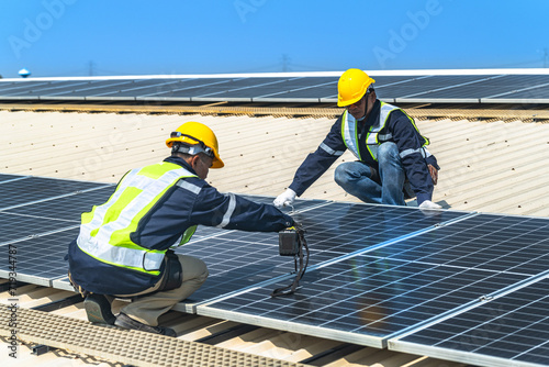 Wallpaper Mural engineer men inspects construction of solar cell panel or photovoltaic cell at roof top. Industrial Renewable energy of green power. factory at urban area. worker working on tower roof. Torontodigital.ca