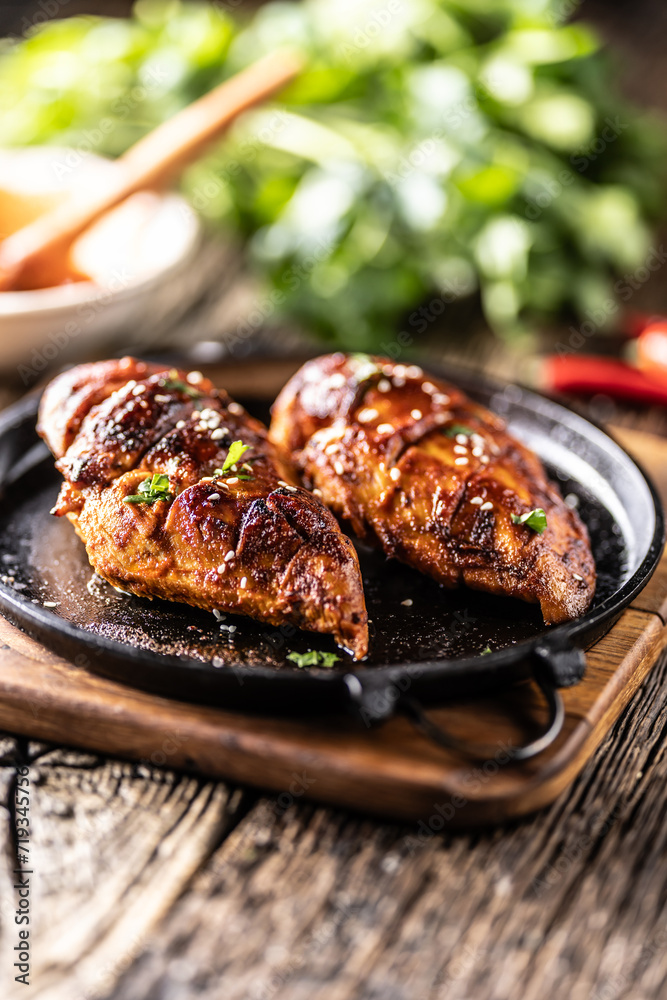 Marinated grilled chicken breast in BBQ sauce and served on a cast iron pan - Close up Marinated grilled chicken breast in BBQ sauce and served on a cast iron pan - Close up