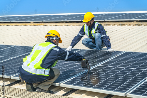 Wallpaper Mural engineer men inspects construction of solar cell panel or photovoltaic cell at roof top. Industrial Renewable energy of green power. factory at urban area. worker working on tower roof. Torontodigital.ca